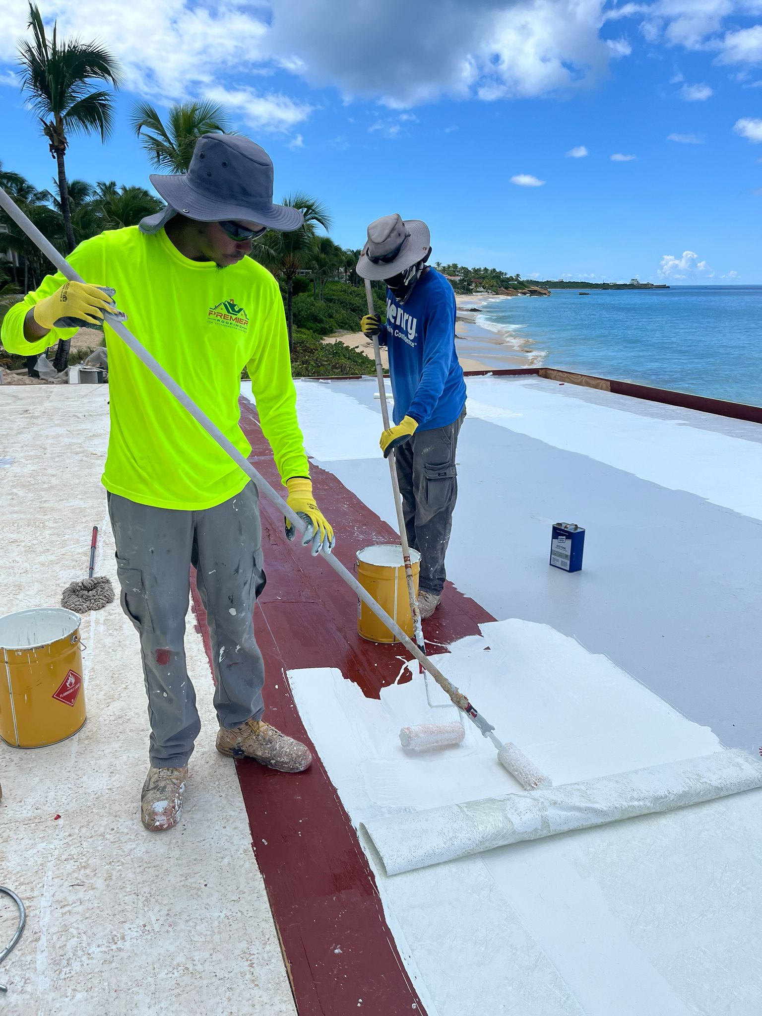 Premier Roofing crew applying a liquid-applied roof system on a beachfront property in Anguilla — Henry-certified applicator team